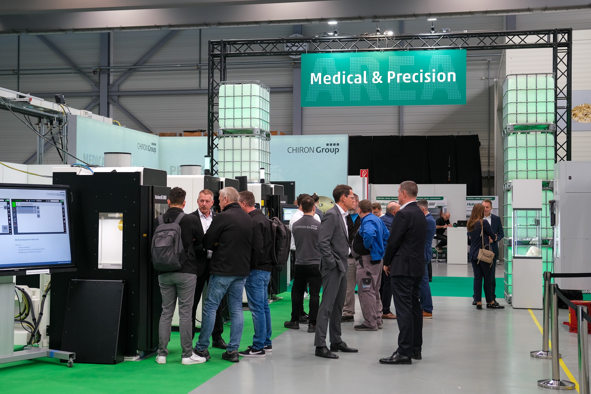 Großflächige Deckenbanner sorgten für schnelle Orientierung, beleuchtete Gitterboxen unterstrichen den industriellen, praxisnahen Charakter der Hausmesse und prägten das klare Gesamtbild.